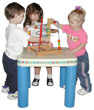 photograph of 3 children playing with building blocks on a table