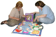 Two adults playing with two infants